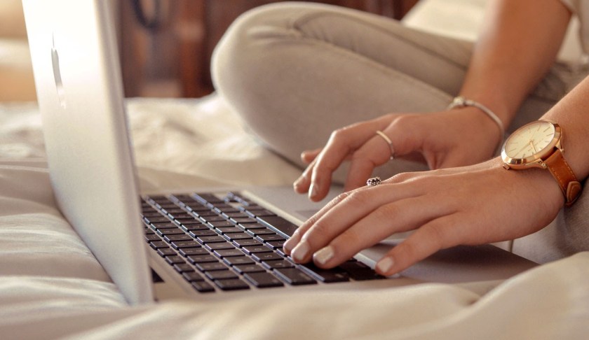 FILE: Woman working from a computer on a bed. Work from home is growing in during the holiday season.