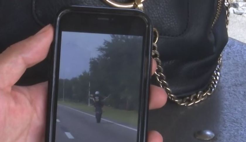 Smartphone shows footage of stunt driver. Photo via WINK News.