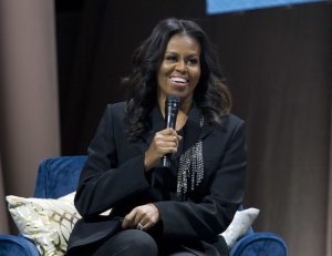 Michelle Obama speaks to the crowd as she presents her memoir during her book tour stop in Washington. Photo via AP/Jose Luis Magana.