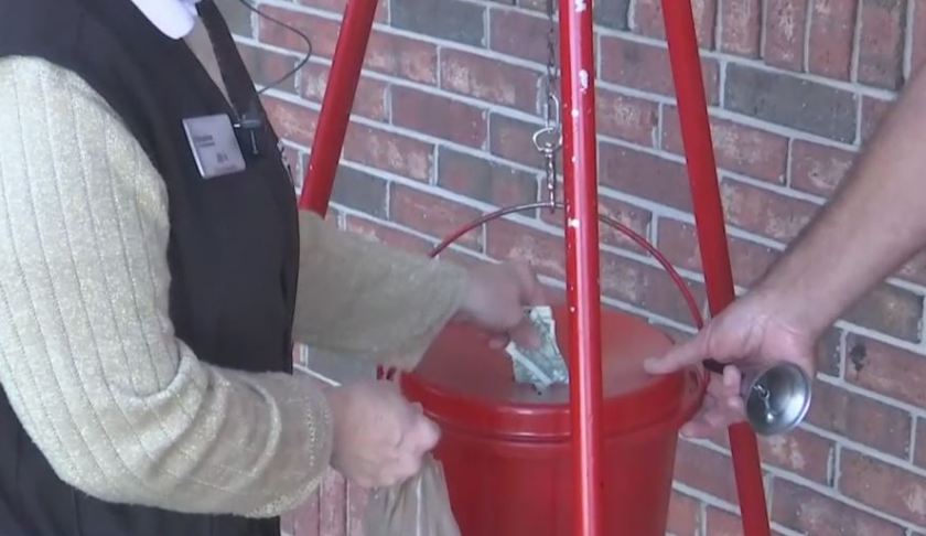 A person donating money to the Salvation Army. Photo via WINK News.