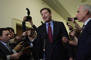 Former FBI Director James Comey, center, standing with his attornery David Kelley, right, speaks to reporters on Capitol Hill in Washington, Friday, Dec. 7, 2018, following his appearance before a closed-door hearing with the House Judiciary and House Oversight committees. (AP Photo/Susan Walsh).