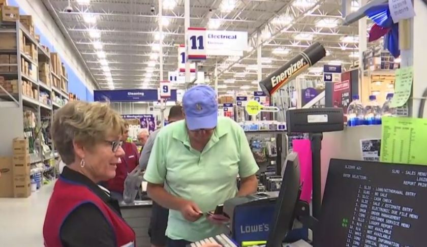 Man pays for items at a store in Collier County. Photo via WINK News.