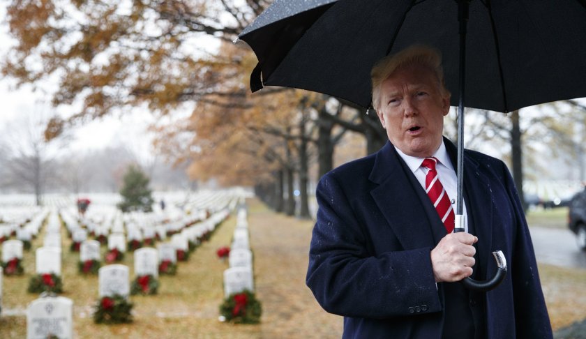President Donald Trump speaks to media he visits Section 60 at Arlington National Cemetery in Arlington, Va., Saturday, Dec. 15, 2018, during Wreaths Across America Day. (AP Photo/Carolyn Kaster)
