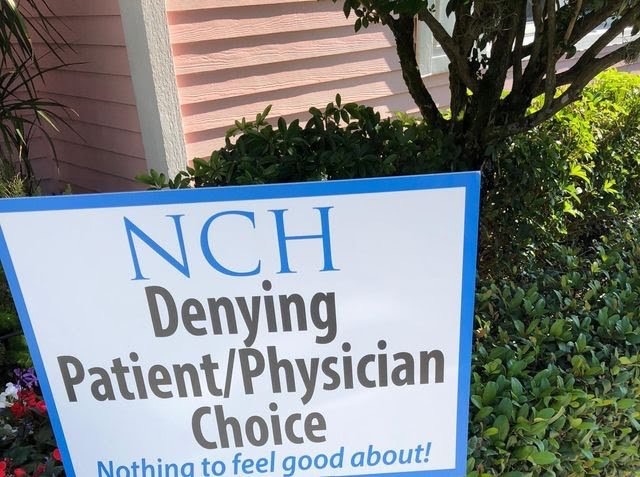Signs claim NCH denies patients the right to choose their own physician. Photo via WINK News.