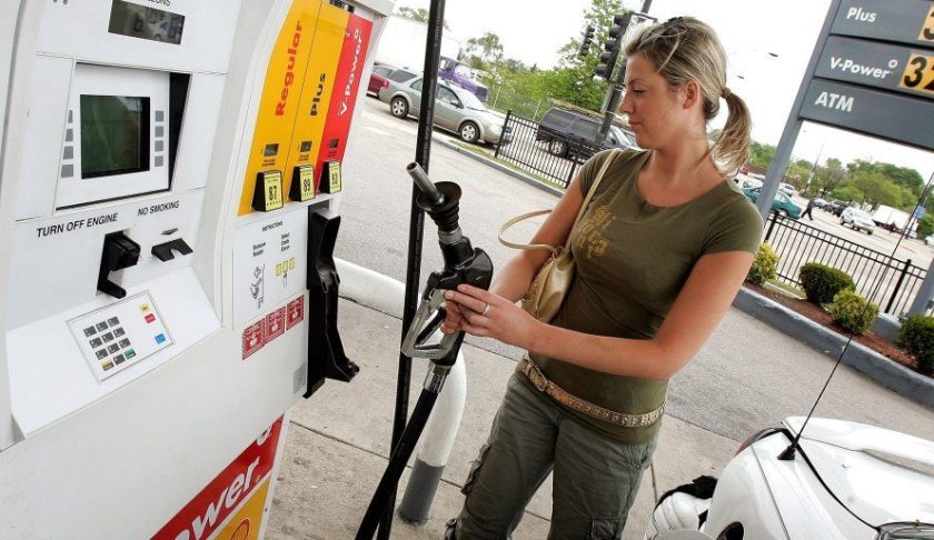 A motorist replaces the gas pump after filling her car at a Shell station. Photo via CBS.