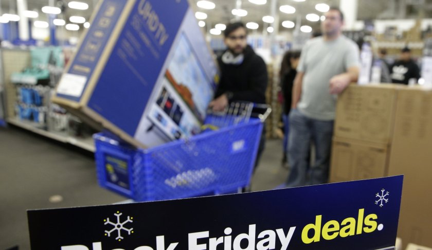 FILE- In this Nov. 22, 2018, file photo people wait in line to buy televisions as they shop during an early Black Friday sale at a Best Buy store on Thanksgiving Day in Overland Park, Kan. The holiday season was a brutal one for U.S. retailers, especially department stores and companies that sell luxury products. (AP Photo/Charlie Riedel, File)