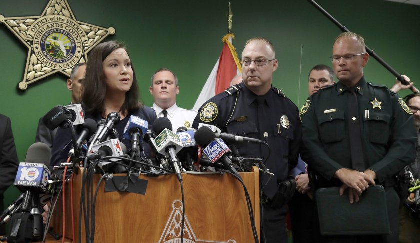 Florida Attorney General Ashley Moody, left, addresses the media as she stands with Sebring Police Chief Karl Hoglund, center, and Highlands County Sheriff Paul Blackman during a news conference, Thursday, Jan. 24, 2019, in Sebring, Fla. Five people were shot and killed on the day before at a SunTrust Bank. (AP Photo/Chris O'Meara)