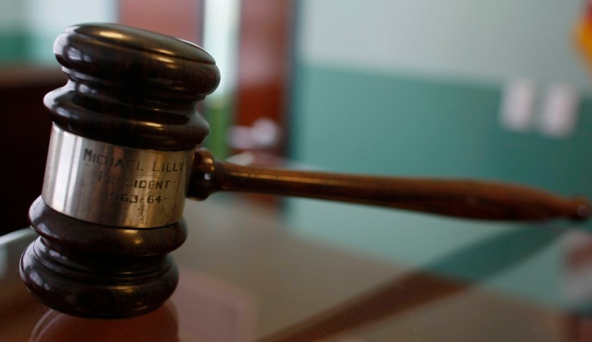 A judges gavel rests on top of a desk in the courtroom. Photo via CBS News.