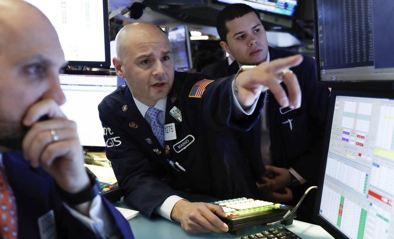 In this Jan. 4, 2019, file photo Mario Picone, center, works with fellow specialists on the floor of the New York Stock Exchange. Photo via AP/Richard Drew.