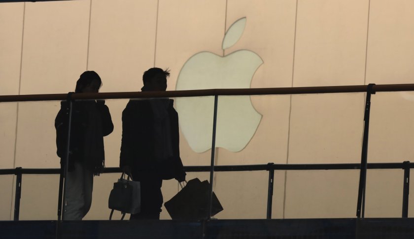 In this Thursday, Jan. 3, 2019, photo, shoppers pass by the Apple store logo at a shopping mall in Beijing. A U.S. delegation led by deputy U.S. trade representative, Jeffrey D. Gerrish arrived in the Chinese capital ahead of trade talks with China. China sounded a positive note ahead of trade talks this week with Washington, but the two sides face potentially lengthy wrangling over technology and the future of their economic relationship. Photo via AP/Ng Han Guan.