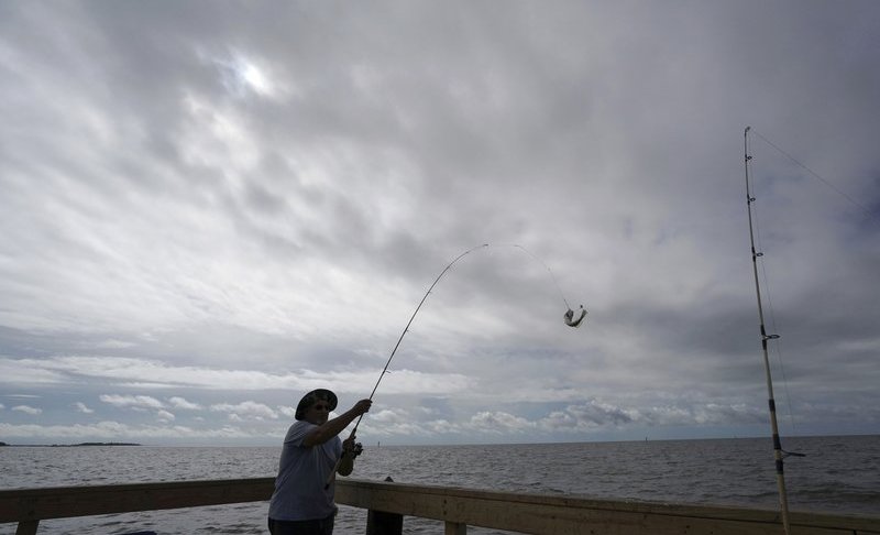In this Sept. 5, 2018 file photo, Tim Hitchens, of Gulfprort, Miss., pulls in a fish while fishing from a pier in the Gulf of Mexico, the morning after Tropical Storm Gordon made landfall nearby, in Biloxi, Miss. The rules that govern recreational marine fishing in the U.S. will get an overhaul due to a new law passed by in December. Photo via AP/Gerald Herbert.