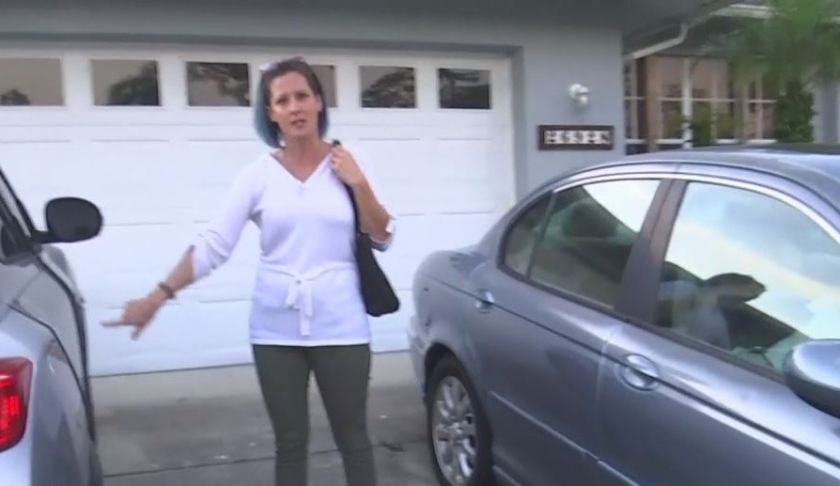 Victim points to an open door on her vehicle after an overnight burglary. Photo via WINK News.