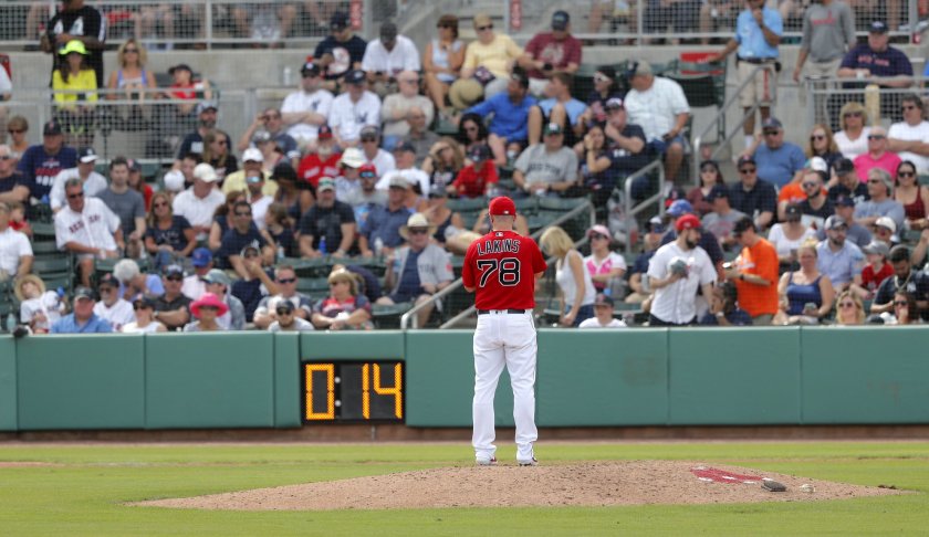 Boston Red Sox pitcher Travis Lakins prepares to pitch as the pitching clock winds down during a spring training baseball game against the New York Yankees in Fort Myers, Fla., Saturday, Feb. 23, 2019. (AP Photo/Gerald Herbert)