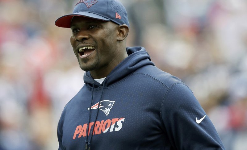 FILE - In this Sept. 9, 2018, file photo, New England Patriots linebackers coach Brian Flores watches his team warm up before an NFL football game against the Houston Texans in Foxborough, Mass. The Miami Dolphins have called a news conference for Monday, Feb. 4, 2019, and are expected to introduce Brian Flores as their coach less than 24 hours after he helped the New England Patriots win the Super Bowl. (AP Photo/Charles Krupa, File)