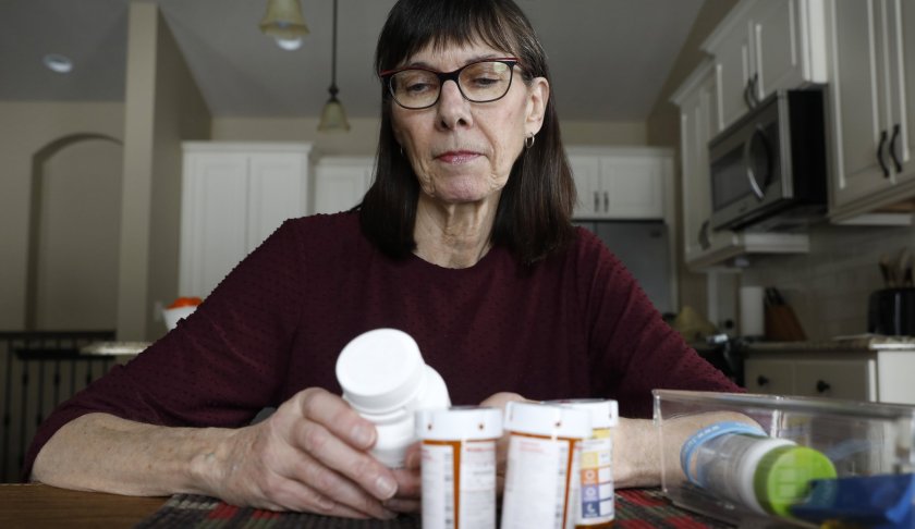 Retired public school teacher Gail Orcutt, of Altoona, Iowa, looks over some of the prescription drugs she takes, Friday, Feb. 15, 2019, in Altoona, Iowa. Orcutt pays $2,600 the first month of the year, and then $750 every other month for a lung cancer medication. With health care a top issue for American voters, Congress may actually be moving toward doing something this year to address the high cost of prescription drugs. (AP Photo/Charlie Neibergall)