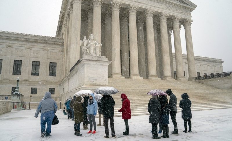 Visitors wait to enter the Supreme Court as a winter snow storm hits the nation's capital making roads perilous and closing most Federal offices and all major public school districts, on Capitol Hill in Washington, Wednesday, Feb. 20, 2019. The Supreme Court is ruling unanimously that the Constitution's ban on excessive fines applies to the states. The outcome Wednesday could help an Indiana man recover the $40,000 Land Rover police seized when they arrested him for selling about $400 worth of heroin. (AP Photo/J. Scott Applewhite)