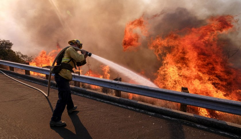 Firefighter battles the flames. (Credit: AP)