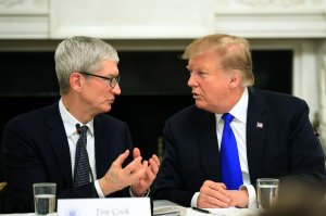 FILE - In this Wednesday, March 6, 2019 file photo, President Donald Trump talks to Apple Inc. CEO Tim Cook during the American Workforce Policy Advisory Board's first meeting in the State Dining Room of the White House in Washington. To President Donald Trump, it was an awkward slip of the lip. To Apple CEO Tim Cook, it was an opportunity to poke some lighthearted fun at a president who has often clashed with the tech industry. A day after Trump mistakenly referred to Cook at a Wednesday White House meeting as “Tim Apple” — an understandable slip, perhaps, coming from the head of the Trump Organization — Cook quietly changed his Twitter account, replacing his last name with the Apple logo. (AP Photo/Manuel Balce Ceneta, File)