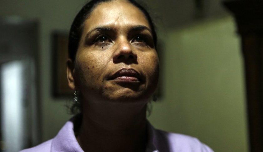 In this Thursday, March 28, 2019 photo, Wanda Gomez, a survivor of domestic violence, poses in her home, in Miami, Fla. According to Gomez, 12 years have passed since she was nearly stabbed to death by an ex-boyfriend. Following her assault, she was advised by authorities to quit her job and leave her home. She lost her ability to make a living and provide a safe living environment for her family. Gomez said she could have benefited from a bill currently making its way through Florida Legislature. If passed, the law would grant victims of domestic violence the right to receive unemployment compensation. According to data, 41 states across the U.S. provide unemployment benefits to victims of domestic assault. (AP Photo/Ellis Rua)