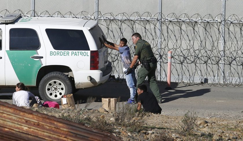 FILE - In this Dec. 15, 2018, file photo, Honduran asylum seekers are taken into custody by U.S. Border Patrol agents after the group crossed the U.S. border wall into San Diego, Calif., seen from Tijuana, Mexico. Detained asylum seekers who have shown they have a credible fear of returning to their country will no longer be able to ask a judge to grant them bond. U.S. Attorney General William Barr decided Tuesday, April 16, 2019, that asylum seekers who clear a "credible fear" interview and are facing removal don't have the right to be released on bond while their cases are pending and will have to wait in detention until their case is adjudicated. (AP Photo/Moises Castillo, File)