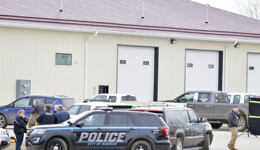 Mandan, N.D. Police Deputy Chief Lori Flaten, left, and other law enforcement personnel stand outside the scene on the south side the RJR Maintenance and Management property in Mandan, N.D., Monday, April 1, 2019. (Mike McCleary/The Bismarck Tribune via AP)