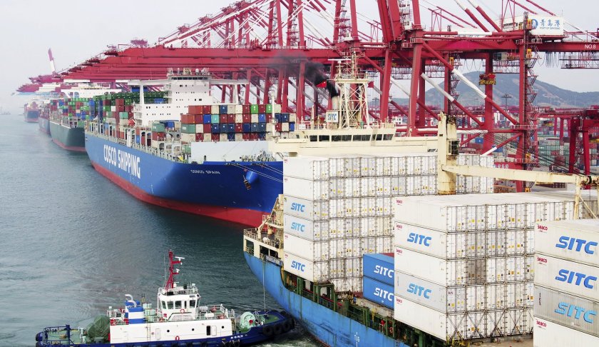 In this Wednesday, May 8, 2019, photo, a barge pushes a container ship to the dockyard in Qingdao in eastern China's Shandong province. (Chinatopix via AP)
