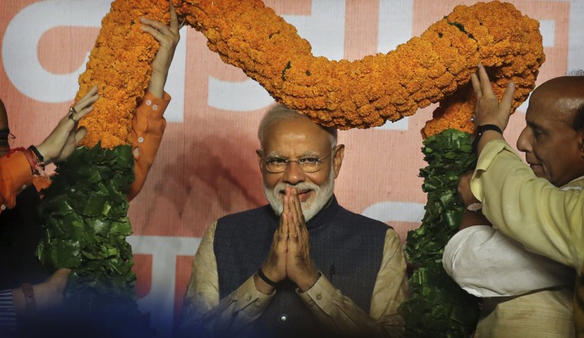 Indian Prime Minister Narendra Modi receives a giant floral garland from party leaders at their headquarters in New Delhi, India, Thursday, May 23, 2019. Indian Prime Minister Narendra Modi's party claimed it had won reelection with a commanding lead in Thursday's vote count, while the stock market soared in anticipation of another five-year term for the pro-business Hindu nationalist leader. (AP Photo/Manish Swarup)