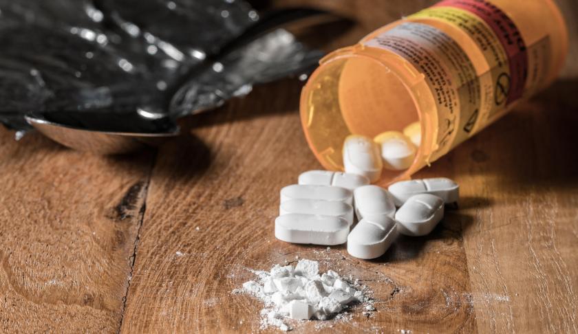 Pills of Oxycodone on a wooden table. (Credit CBS News)