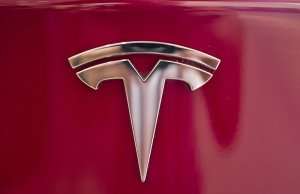 FILE - This Wednesday, Aug. 8, 2018, file photo shows the Tesla emblem on the back end of a Model S in the Tesla showroom in Santa Monica, Calif. Faced with a slumping stock price and questions about demand for its vehicles, Tesla has lowered the U.S. base prices of its two most expensive models. The company on Monday, May 21, 2019 cut $3,000 from the price of the Model S sedan and $2,000 from the Model X SUV. (AP Photo/Richard Vogel, File)