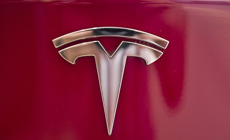 FILE - This Wednesday, Aug. 8, 2018, file photo shows the Tesla emblem on the back end of a Model S in the Tesla showroom in Santa Monica, Calif. Faced with a slumping stock price and questions about demand for its vehicles, Tesla has lowered the U.S. base prices of its two most expensive models. The company on Monday, May 21, 2019 cut $3,000 from the price of the Model S sedan and $2,000 from the Model X SUV. (AP Photo/Richard Vogel, File)