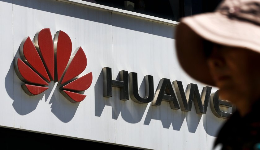 FILE - In this May 29, 2019, file photo, a woman walks by a Huawei retail store in Beijing. The world's largest association of technology professionals has reversed a decision that would have excluded employees of Chinese tech giant Huawei and its affiliates from some editorial and peer review activities.(AP Photo/Andy Wong, File)