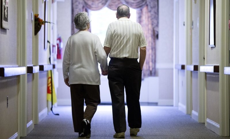 FILE - In this Nov. 6, 2015 file photo, an elderly couple walks down a hall of a nursing home in Easton, Pa. Research released on Tuesday, June 4, 2019 shows fatal falls have nearly tripled in older Americans in recent years, rising to more than 25,000 deaths yearly. (AP Photo/Matt Rourke, File)