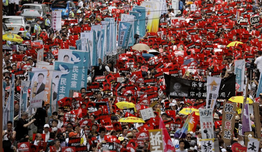 Protesters march along a downtown street against the proposed amendments to an extradition law in Hong Kong Sunday, June 9, 2019. A sea of protesters is marching through central Hong Kong in a major demonstration against government-sponsored legislation that would allow people to be extradited to mainland China to face charges.(AP Photo/Vincent Yu)