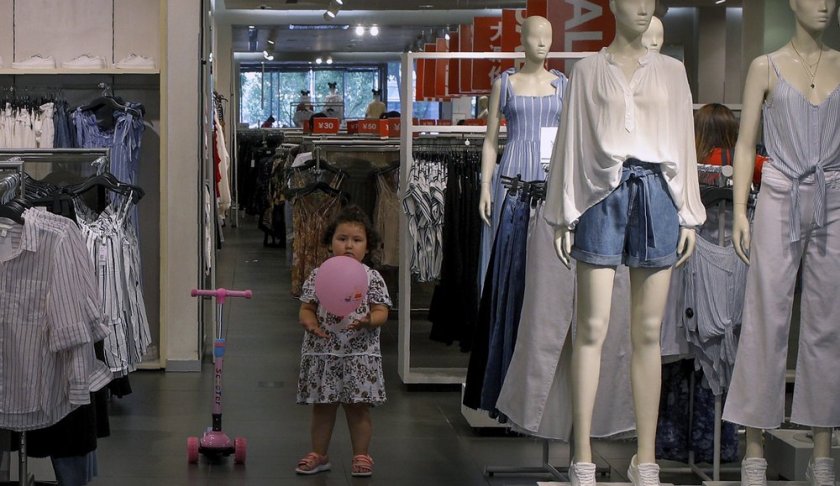 A child plays with a balloon at a clothing store having a promotion sale in Beijing, Monday, July 15, 2019. China's economic growth sank to its lowest level in at least 26 years in the quarter ending in June, adding to pressure on Chinese leaders as they fight a tariff war with Washington. (AP Photo/Andy Wong)