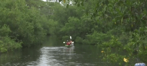 People kayaking move through a waterway polluted with fecal matter. (Credit: WINK News)