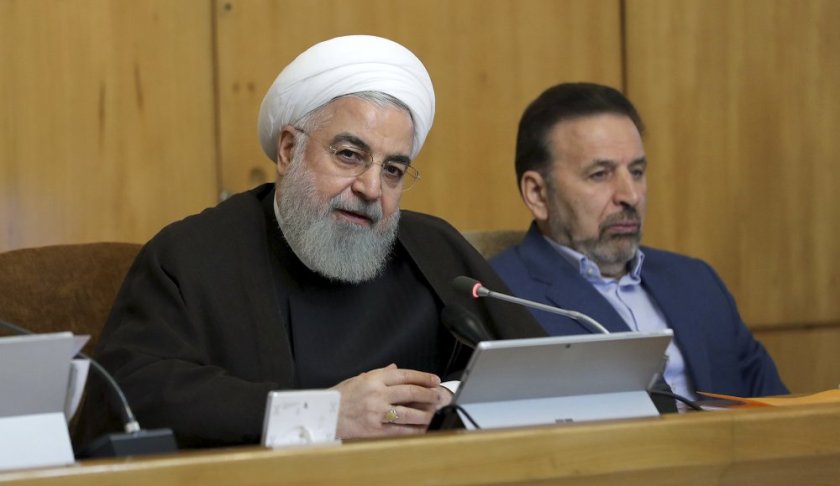 In this photo released by the official website of the office of the Iranian Presidency, President Hassan Rouhani speaks during a cabinet meeting, as President's chief of staff Mahmoud Vaezi sits at right, in Tehran, Iran, Wednesday, July 10, 2019. Rouhani said Wednesday Britain will face "repercussions" over the seizure of an Iranian supertanker. (Iranian Presidency Office via AP)
