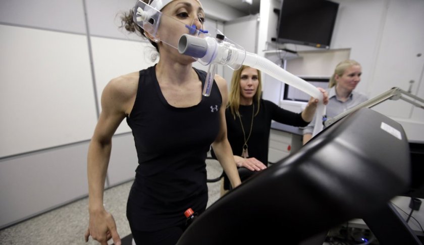 In this April 23, 2019 photo, research scientist Leila Walker, left, is assisted by nutritional physiologist Holly McClung, center, as they demonstrate equipment designed to evaluate fitness levels in female soldiers, not shown, who have joined elite fighting units such the Navy Seals, at the U.S. Army Research Institute of Environmental Medicine, at the U.S. Army Combat Capabilities Development Command Soldier Center, in Natick, Mass. (AP Photo/Steven Senne)
