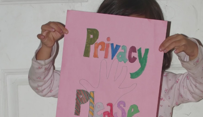 Child holds up a sign asking for privacy. (Credit: WINK News)