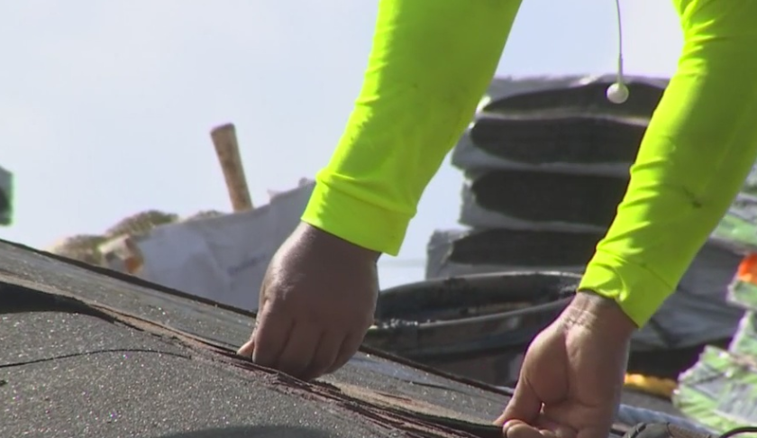 Construction worker does roof repairs. (Credit: WINK News)