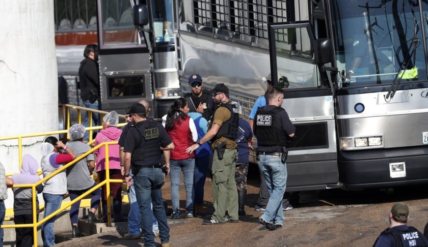 dcuffed female workers are escorted into a bus for transportation to a processing center following a raid by U.S. immigration officials at a Koch Foods Inc., plant in Morton, Miss., Wednesday, Aug. 7, 2019. U.S. immigration officials raided several Mississippi food processing plants on Wednesday and signaled that the early-morning strikes were part of a large-scale operation targeting owners as well as employees. (AP Photo/Rogelio V. Solis)