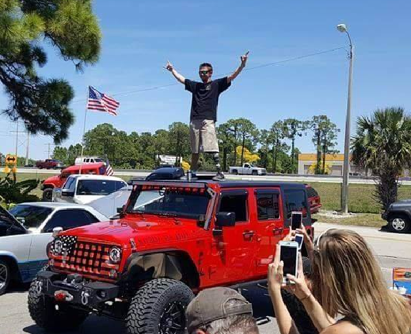 Jeff Kelly, an Army veteran, stands on top of his car. (Credit: WINK News)