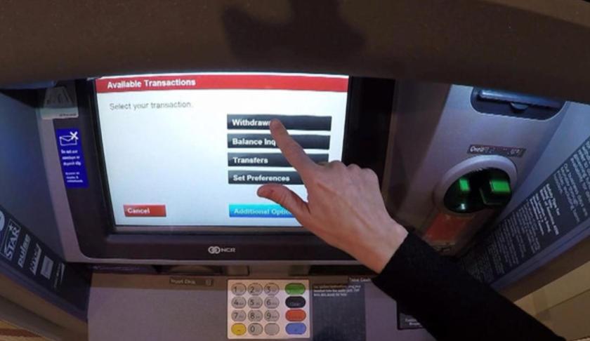 Person at an ATM. (Credit: CBS News)