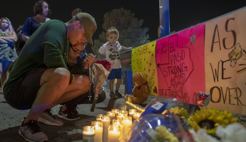Rene Aguilar and Jackie Flores pray at a makeshift memorial for the victims of Saturday's mass shooting at a shopping complex in El Paso, Texas, Sunday, August 4, 2019. (AP Photo/Andres Leighton)