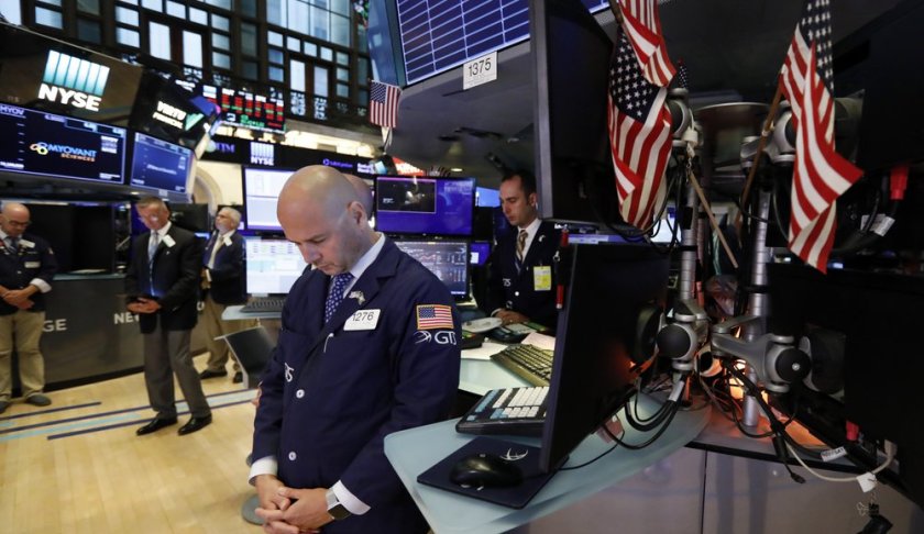 Traders pause for a moment of silence on the floor of the New York Stock Exchange, for the victims of the weekend shootings, Monday, Aug. 5, 2019. (AP Photo/Richard Drew)