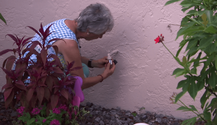 Jo-Ann Piacente installs a bibb lock on a water spigot at her Cape Coral home. (WINK News)
