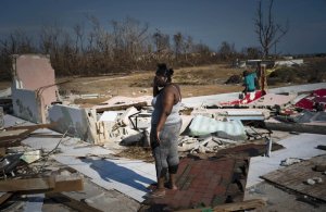 FILE: A woman is overcome as she looks at her house destroyed by Hurricane Dorian, in High Rock, Grand Bahama, Bahamas, Friday Sept. 6, 2019. The Bahamian health ministry said helicopters and boats are on the way to help people in affected areas, though officials warned of delays because of severe flooding and limited access. (AP Photo/Ramon Espinosa/FILE)