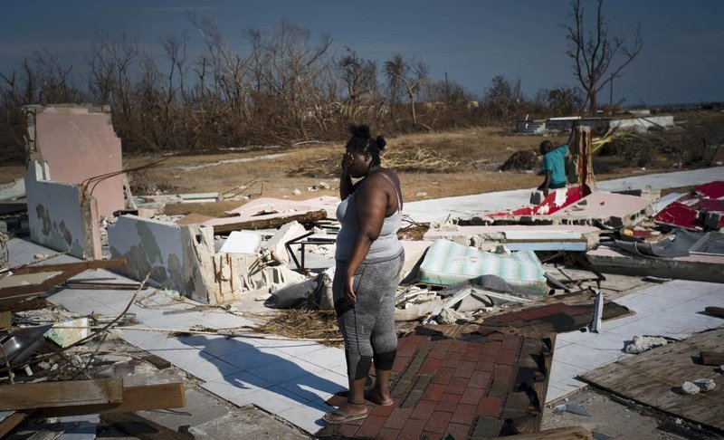 FILE: A woman is overcome as she looks at her house destroyed by Hurricane Dorian, in High Rock, Grand Bahama, Bahamas, Friday Sept. 6, 2019. The Bahamian health ministry said helicopters and boats are on the way to help people in affected areas, though officials warned of delays because of severe flooding and limited access. (AP Photo/Ramon Espinosa/FILE)