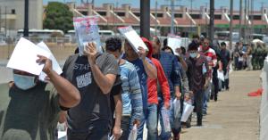 United States Border Patrol officers return a group of migrants back to the Mexico side of the border as Mexican immigration officials check the list, in Nuevo Laredo, Mexico, Thursday, July 25, 2019. Mexico has received some 20,000 asylum seekers returned to await U.S. immigration court dates under the program colloquially known as "remain in Mexico." (AP Photo/Salvador Gonzalez)