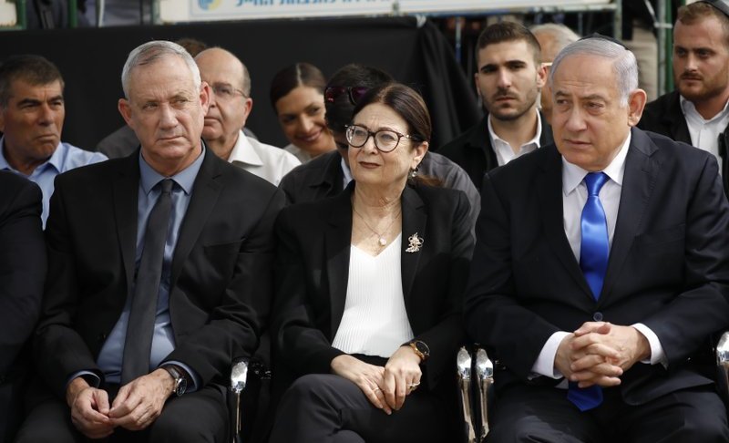 FILE - In this Thursday, Sept. 19, 2019 file photo, Blue and White party leader Benny Gantz, left, Esther Hayut, the Chief Justice of the Supreme Court of Israel, and Prime Minister Benjamin Netanyahu attend a memorial service for former President Shimon Peres in Jerusalem. Israel's two largest political parties are meeting to discuss the possibility of forming a unity government between them, after last week's deadlocked national elections. The Sept. 23 meeting comes a day after Blue and White leader Benny Gantz and Prime Minister Benjamin Netanyahu of the rival Likud party held their first meeting since the polling.(AP Photo/Ariel Schalit, File)
