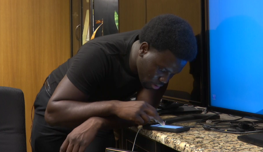 Jaz Jeanty vigilantly checks his smartphone, praying for a positive message about his 20-year-old brother in the Bahamas. (Credit: WINK News)